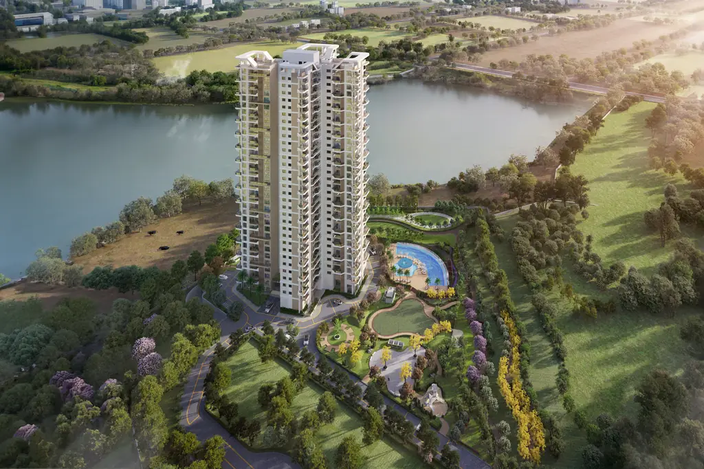 Aerial view of The Solitaire tower beside the lake, with lawns, trees and the township's green edge