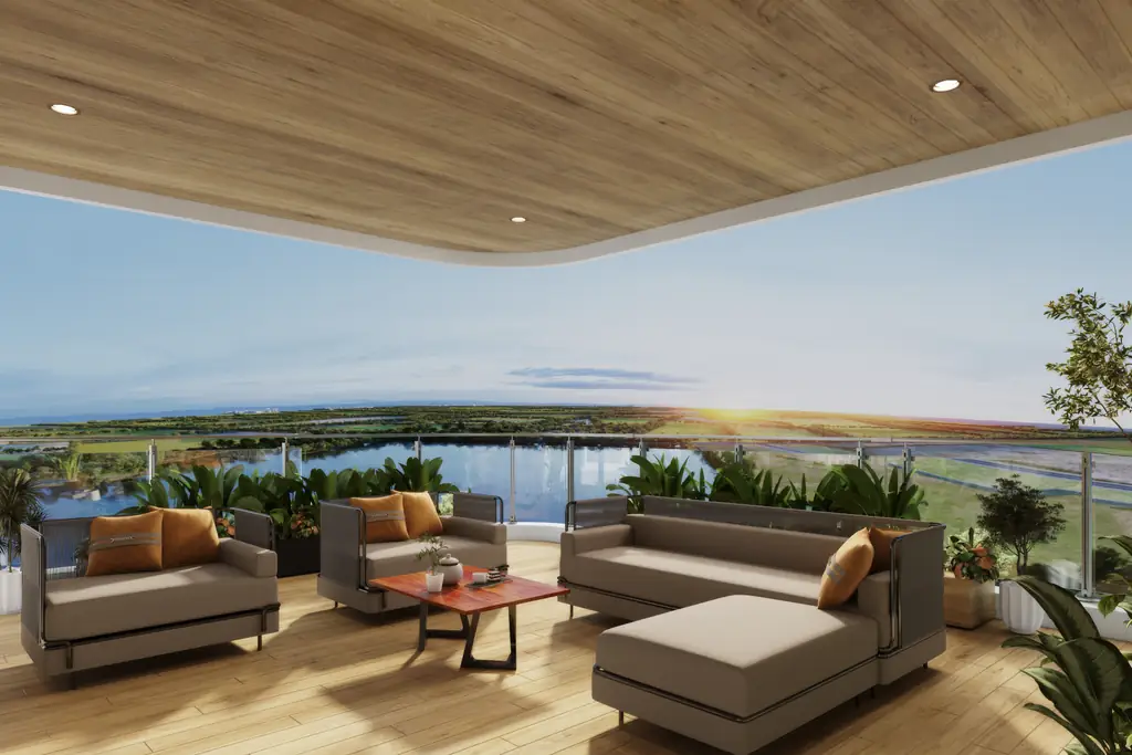 A balcony lounge with orange cushions looking out over the lake at sunset