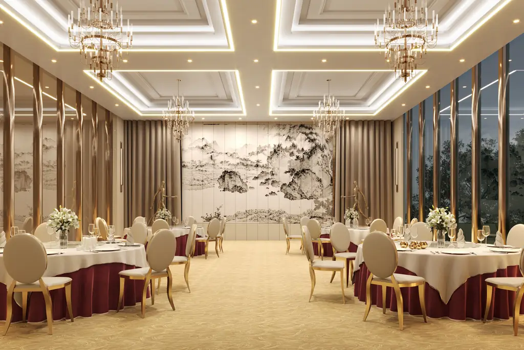 A banquet hall laid with round tables under two chandeliers