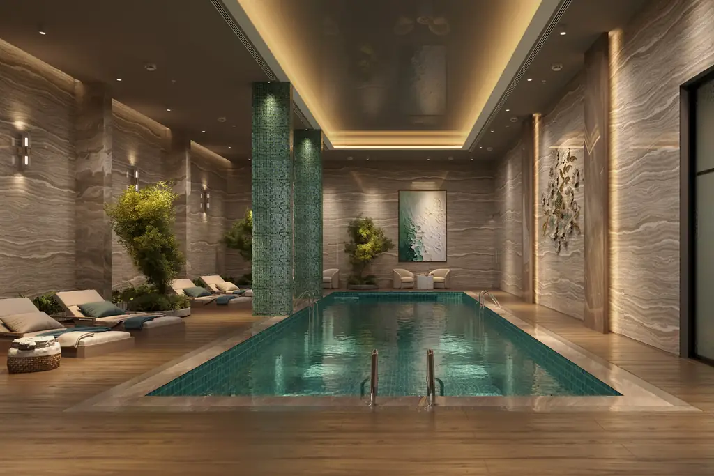 An indoor lap pool lined in stone and timber, loungers along one side