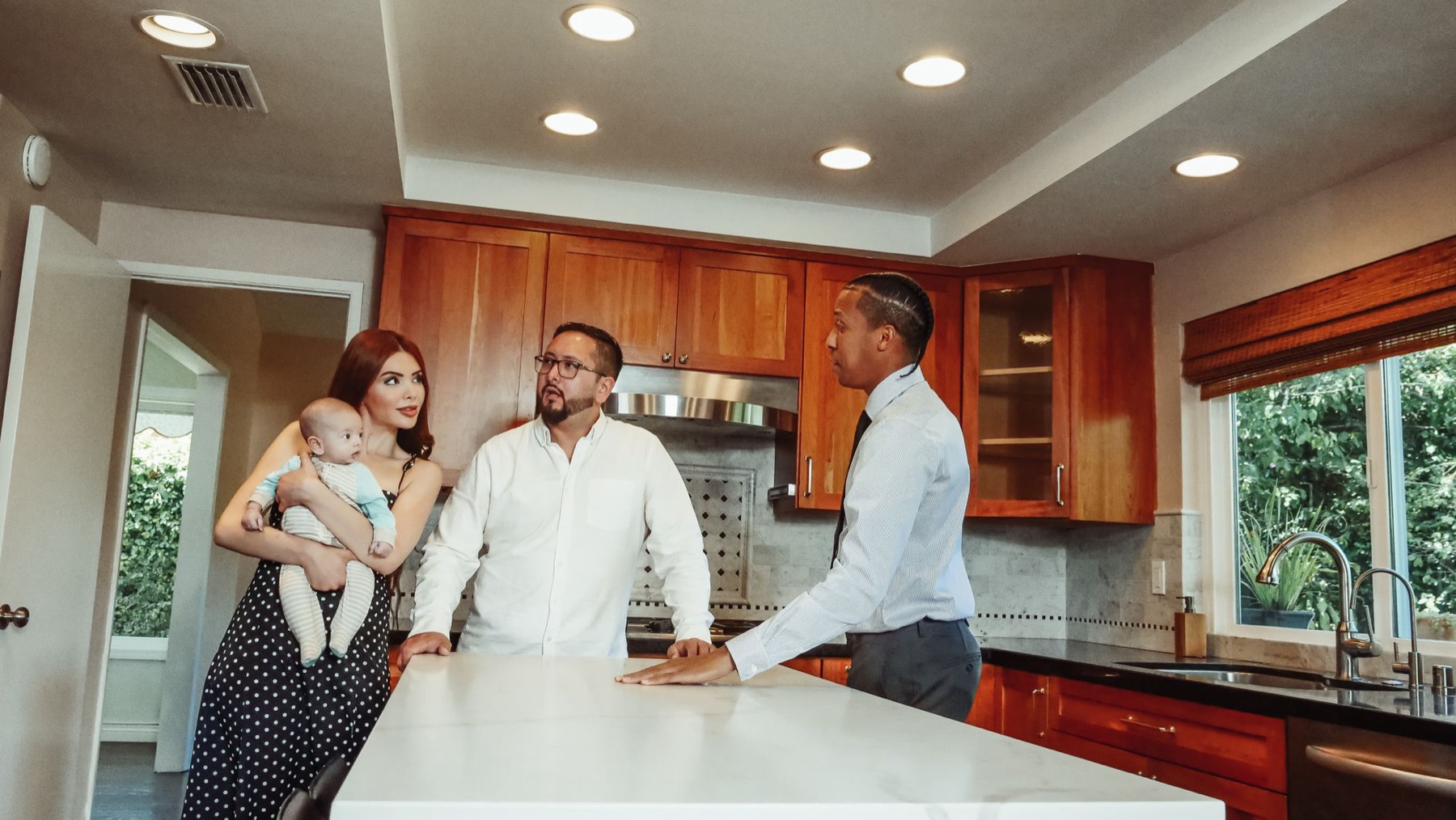 A sales manager showing a young family the kitchen of a show flat