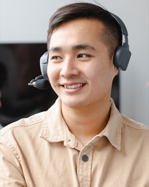 A calling agent in a headset, smiling mid-call