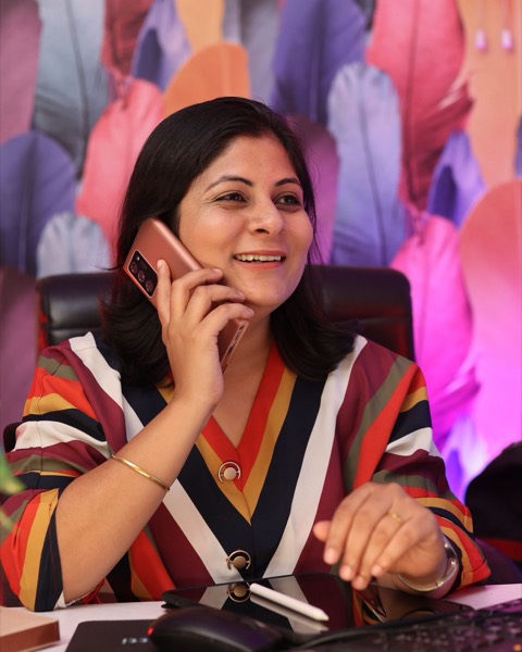A relationship manager on her phone at her desk, laughing