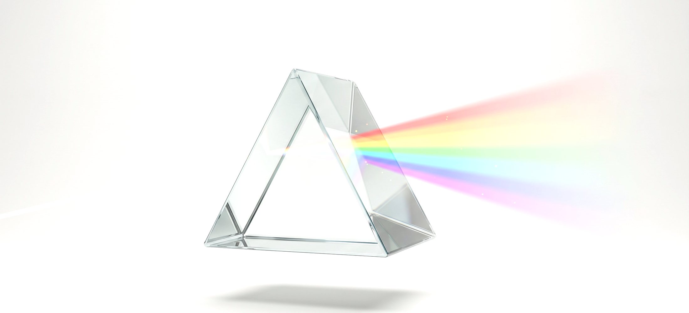 A glass prism splitting a beam of white light into seven colours